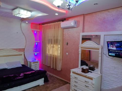 a bedroom with a bed and a mirror and a tv at Riad Khadija: Relax & Explore in Taroudant