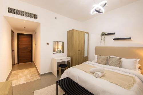ein Schlafzimmer mit einem großen Bett und einem Schreibtisch in der Unterkunft Luxury Brand New 1BD Apt in AJMAN FREE Parking NEAR Beach in Ajman 
