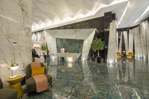 een lobby met een bad en een persoon in een gebouw bij Luxury Brand New 1BD Apt in AJMAN FREE Parking NEAR Beach in Ajman 