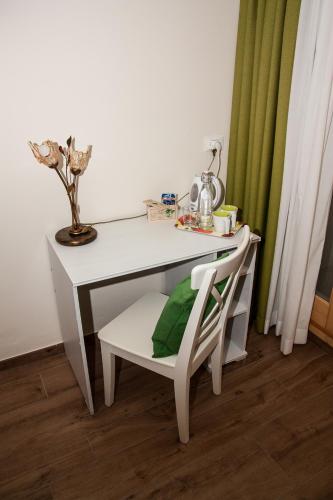 a white desk with a chair and a plant at B&B Incanto in Cles