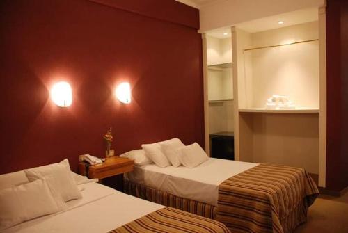 a hotel room with two beds and a red wall at CATANGE HOTEL in Charata