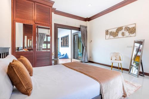a bedroom with a large white bed and some windows at Asia Paradise Pool Villa, Jomtien Beach, Pattaya in Jomtien Beach