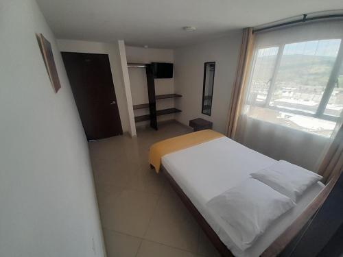 a bedroom with a bed and a large window at HOTEL LA RUEDA SR in Barbosa