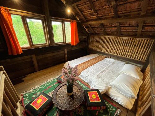 a small bed in a room with a table at Boong House in Bao Loc
