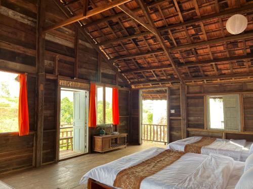 um quarto com 2 camas e um tecto de madeira em Boong House em Bao Loc