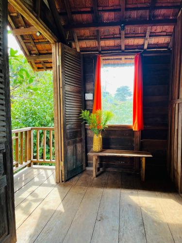 a porch of a house with a window and a bench at Boong House in Bao Loc