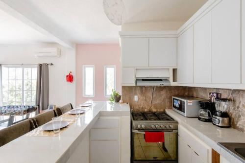 uma cozinha com armários brancos e um forno com placa de fogão em Casa Sol Descanso y Diversion em San José del Cabo