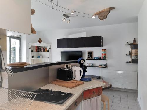 - une cuisine avec des murs blancs et un comptoir dans l'établissement Appartement cosy, 4 pers, proche plages et centre, BBQ, parking, Wifi inclus - FR-1-239-943, à Capbreton