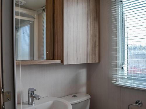 a bathroom with a sink and a toilet and a mirror at Merse Place 154 - Uk45160 in Mainsriddle