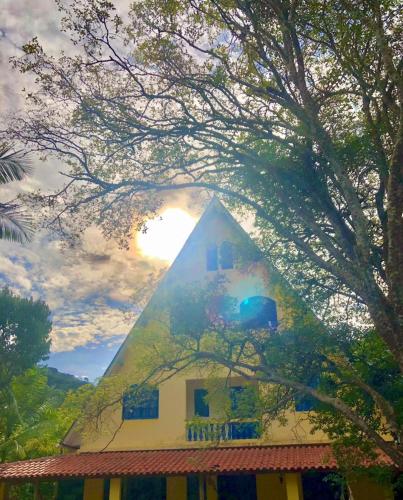 un edificio pirámide con el sol en el fondo en Cantinho vovó Nita, en Marechal Floriano