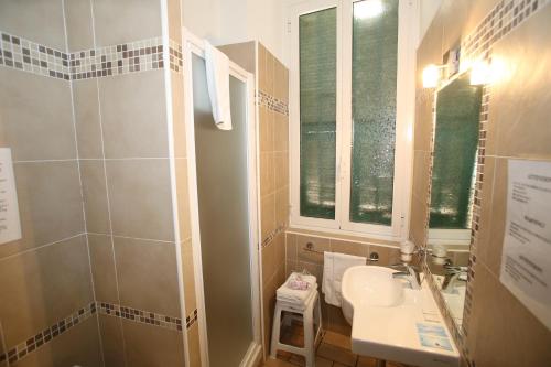 a small bathroom with a sink and a mirror at Sakura Inn Sanremo in Sanremo