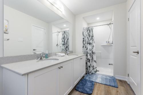 a white bathroom with a sink and a shower at Luxury Town close to Fairview Casino in Niagra Falls in Niagara Falls