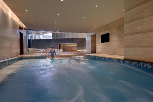 a woman is standing in a swimming pool at Yanqi Hotel, Managed by Kempinski in Huairou