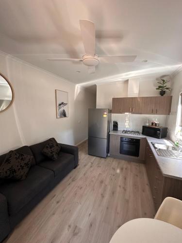 a living room with a couch and a kitchen at Bundalong Villas in Bundalong