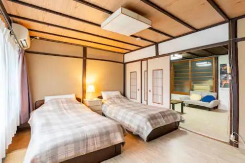 a bedroom with two beds and a couch at Daitokuji Sushicho in Kyoto