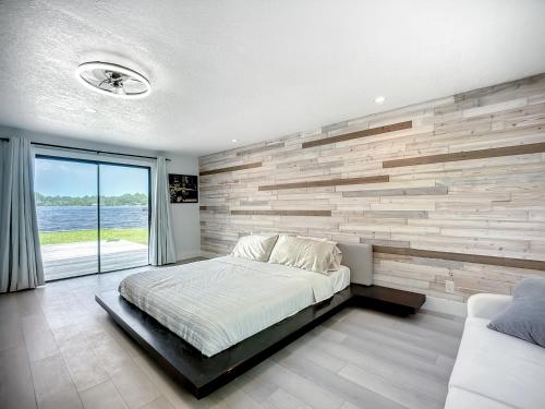 a bedroom with a wooden accent wall and a bed at Trout River Oasis in Jacksonville