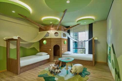 a childrens room with two bunk beds and a play area at Renaissance Kuala Lumpur Hotel & Convention Centre in Kuala Lumpur
