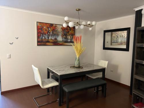 a dining room with a table and chairs and a painting at Departamento Lujo 3A 2B Borde Rio in Calama