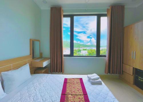a bedroom with a bed with a large window at Chau Gia Hotel in Vĩnh Hy