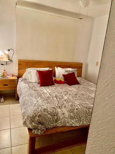 - une chambre avec un lit doté d'oreillers rouges et blancs dans l'établissement Casa Puko, à Acapulco