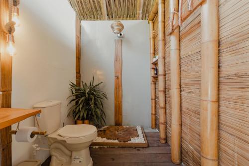 a bathroom with a toilet and a wooden wall at Finca y Glamping Grinta in El Peñol