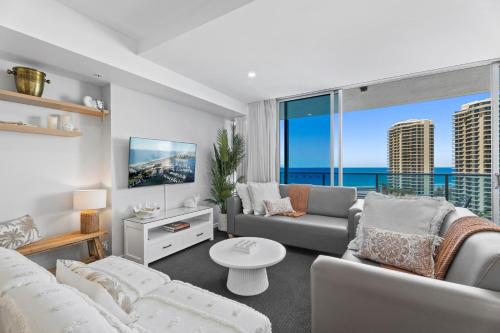 a living room with white furniture and a large window at H-Residences - GCLR in Gold Coast