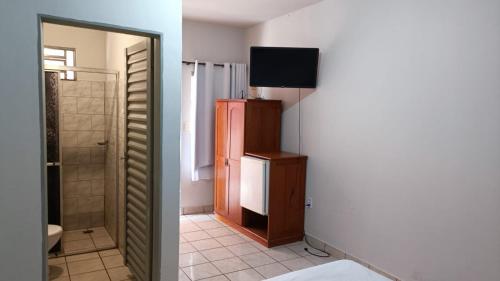 a room with a bathroom with a television and a room with a toilet at Hotel Turazzi in Cáceres