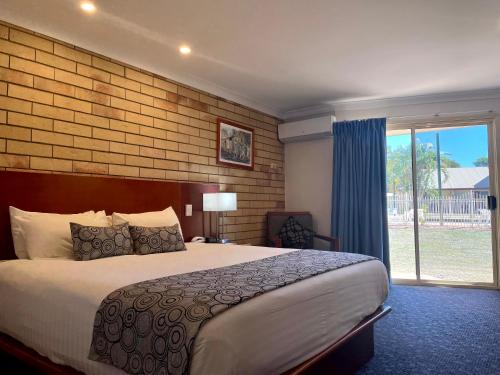 ein Schlafzimmer mit einem großen Bett und einem großen Fenster in der Unterkunft Western Heritage Motor Inn in Moranbah