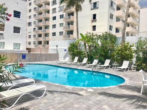 a swimming pool with lounge chairs and a building at Ocean Walk by Miami Ambassadors in Miami Beach