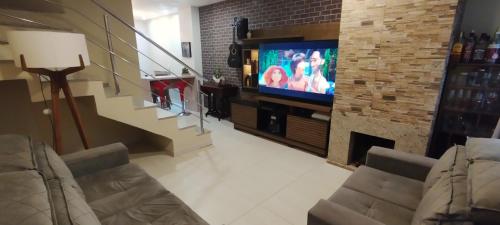 a living room with a television and a fireplace at Casa Joaninha centro in Canela
