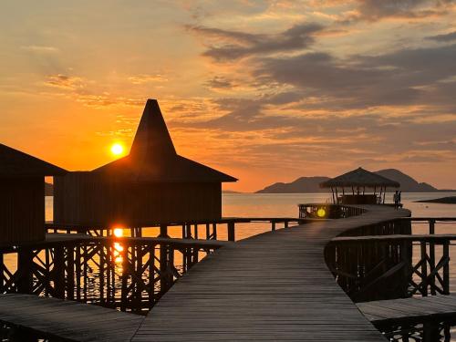 a wooden pathway leading to the ocean at sunset at Menjaga Bay in Labuan Bajo