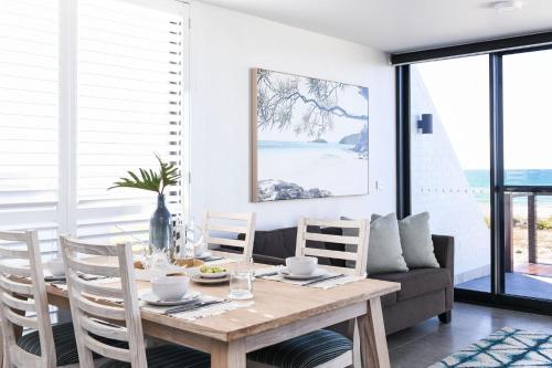 a dining room with a wooden table and chairs at Pacific Dawn on the Beach One in Wooli