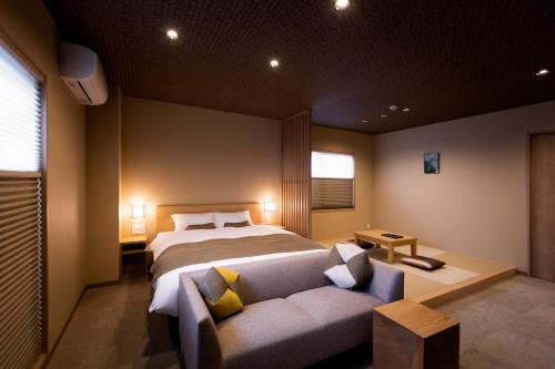 a bedroom with a bed and a couch at Rinn Kitagomon in Kyoto