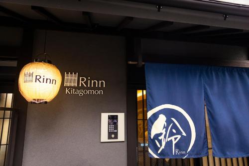 two signs on the wall of a building at Rinn Kitagomon in Kyoto