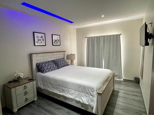 um quarto com uma cama grande e uma luz azul em Departamento Cantiles Dorados em Raulis