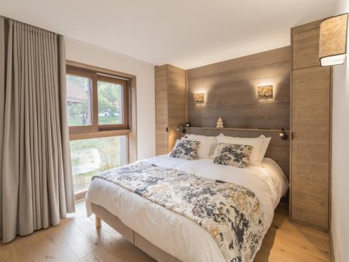 a bedroom with a large bed and a window at Charmant appartement neuf proche des pistes à Courchevel Le Praz, parking et wifi inclus - FR-1-568-45 in Courchevel