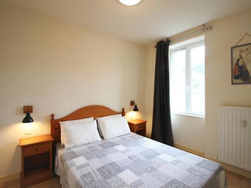 une chambre avec un lit et une grande fenêtre dans l'établissement Appartement T2 à La Bourboule avec WiFi, parking, animaux acceptés - FR-1-608-254, à La Bourboule