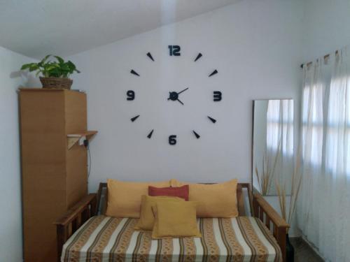 un reloj en una pared sobre una cama en una habitación en LENA'S en Tinogasta