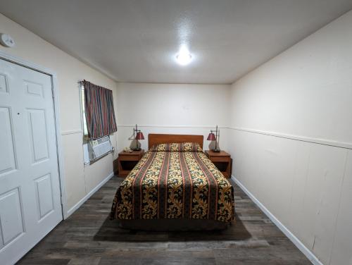 ein Schlafzimmer mit einem Bett in einem weißen Zimmer in der Unterkunft Economy Inn Kingsville in Kingsville