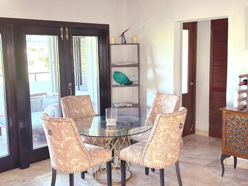 a dining room with a glass table and chairs at Come, Enjoy & Relax at Rio Mar Cluster II, Rio Grande, PR in Rio Grande