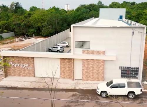 a white house with two cars parked on the roof at Capuzzo Flat 1 in Redenção