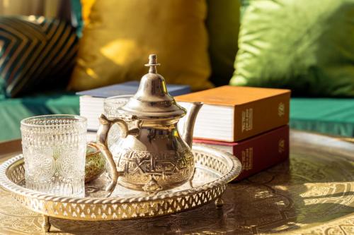a tea pot on a tray on a table with books at The Arabian Nights B&B in Chongqing