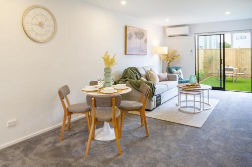 Una sala de estar con una mesa y sillas y un sofá. en Sanctuary close to the beach with Sofa Bed, en Christchurch