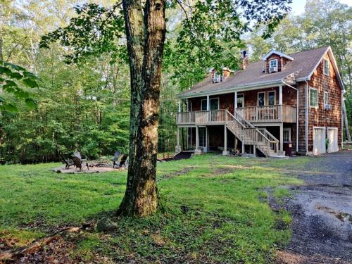 a large house with a tree in front of it at Catskill Cabin with Firepit & Brilliant Fall Views in Catskill