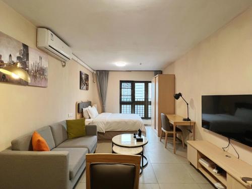 ein Wohnzimmer mit einem Sofa und einem Bett in einem Zimmer in der Unterkunft WESU Weisu Service Apartment - Shenzhen University Nanshan Science and Technolog Park in Shenzhen