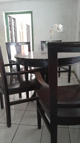 a dining room table and chairs with a table and a mirror at Hotel rejeki in Lewoleba