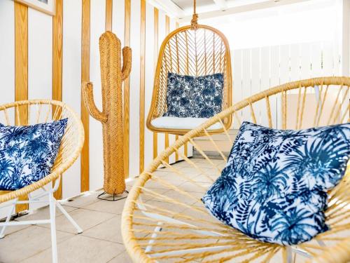 a room with two wicker chairs and a cactus at Studio Casa Sun in Baie Nettle
