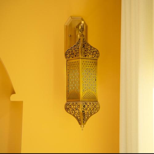 a chandelier hanging on a yellow wall at The Arabian Nights B&B in Chongqing