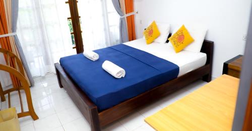 a bedroom with a bed with two towels on it at Andorra Tourist Resort Anuradhapura in Anuradhapura