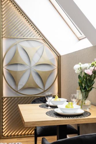 a dining room with a table with glasses and flowers at Góralski Resort Family & SPA in Białka Tatrzanska